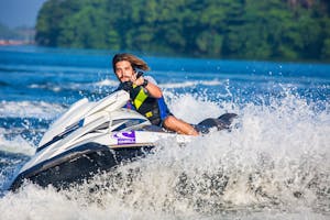 Man enjoying an exhilarating jet ski ride on water, capturing a splash of summer excitement.